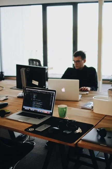 team-03 Moderni ekran računara prikazuje rad na web dizajnu, uz kreativne vizuale u radnom prostoru.